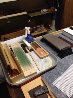 Tray with leather strop and small oil stones for sharpening tools