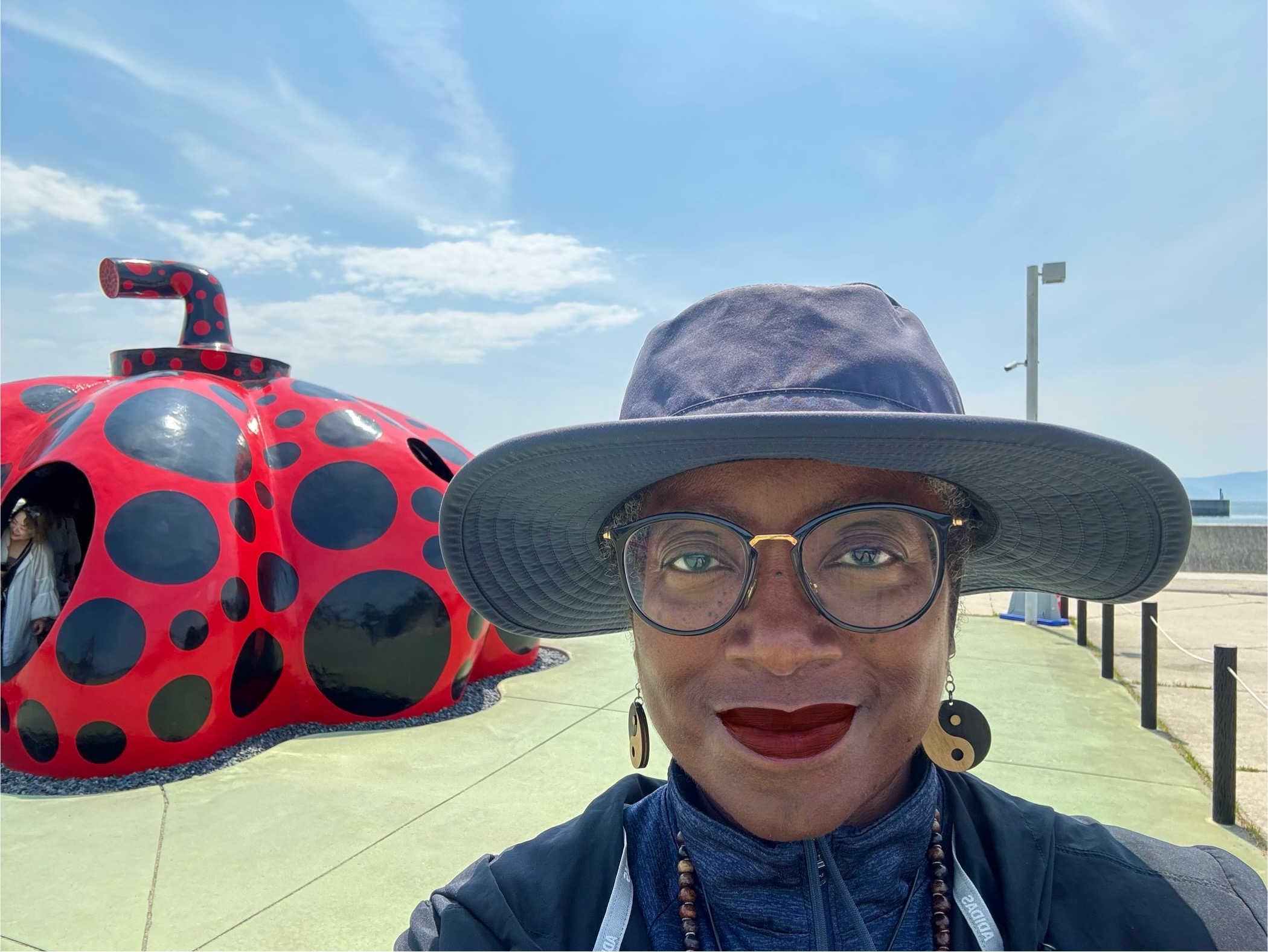 Visitor near red pumpkin at Naoshima island in Japan.