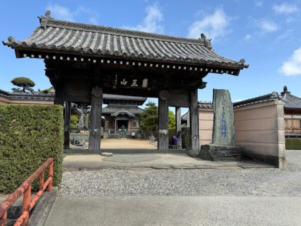 Expeditious ground surface maintenance in front of a temple gate.