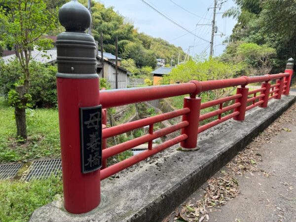 A nice road surface along a red bridge.