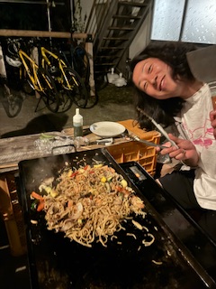 Host of guesthouse cooking the food for the barbecue.