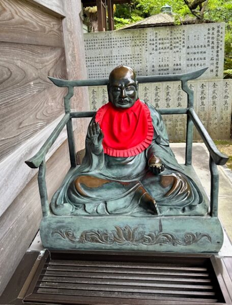 Bronze Jizo sitting outside Daishido at Sankaku-ji temple