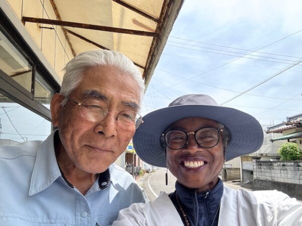 Ohenro and friendly Japanese man without hat in front of renovated Japanese guesthouse.