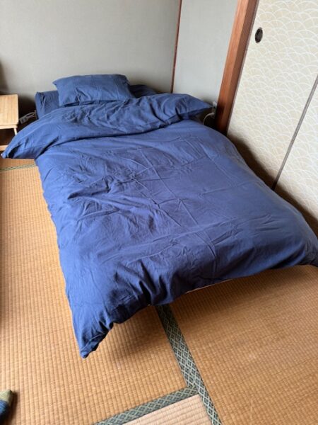 Futon in renovated dormm room in Japanese guesthouse.