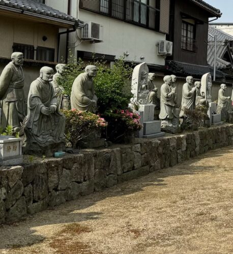 Buddha followers lining outside wall at Zentsu-ji temple.