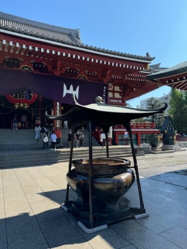 Incense urn at Main hall with purple banner at Senso-ji temple in Tokyo.